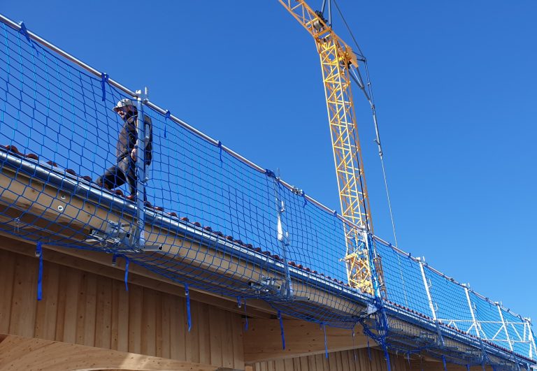Dachfangsystem für sicheres Arbeiten am Dach Dachfangnetz und Seitenschutz an einem Gebäude im Holzbau